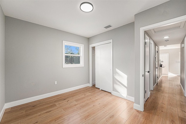 unfurnished bedroom with light wood-type flooring and a closet