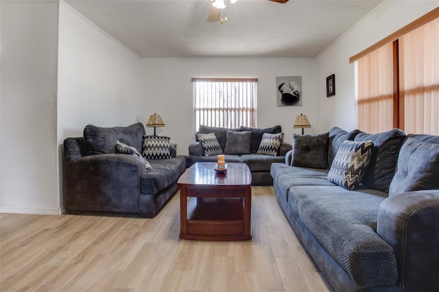 living room with light wood-style floors, crown molding, and ceiling fan