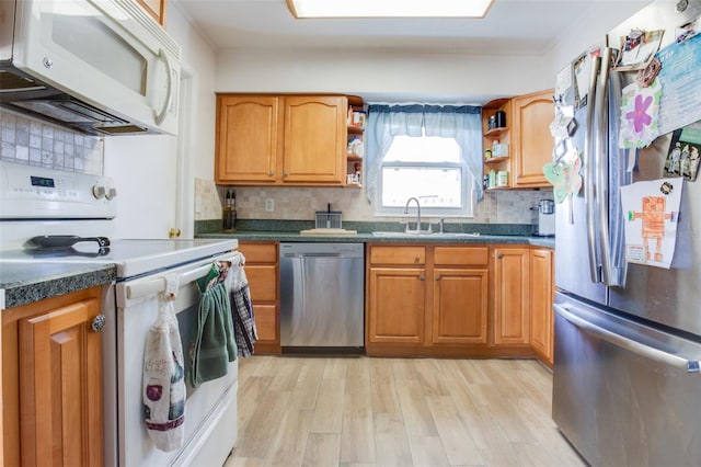 kitchen with open shelves, dark countertops, stainless steel appliances, and a sink