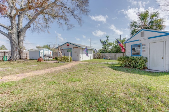 view of yard featuring an outbuilding, fence, and a storage shed