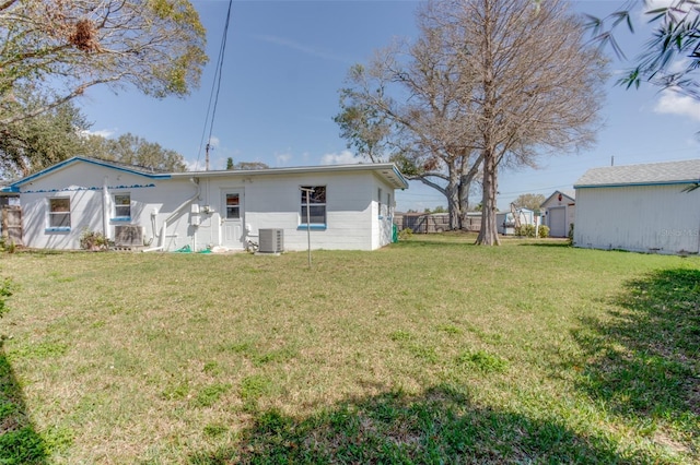 back of property with a lawn and cooling unit