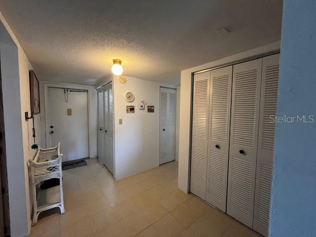 9815 47th Ave N Unit 303, Saint Petersburg, FL 33708 - corridor featuring a textured ceiling and light floors