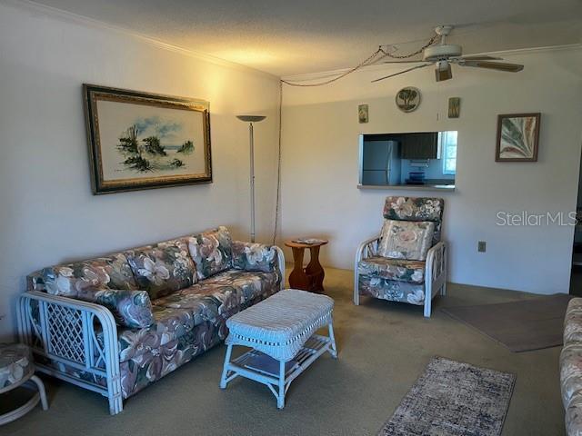 9815 47th Ave N Unit 303, Saint Petersburg, FL 33708 - carpeted living room with a ceiling fan and crown molding
