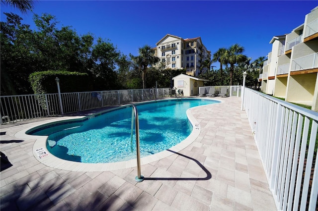 community pool featuring a patio area and fence