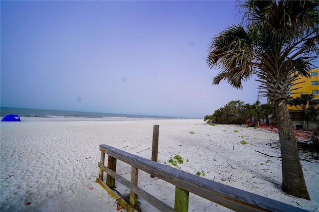 view of dock featuring a water view and a view of the beach