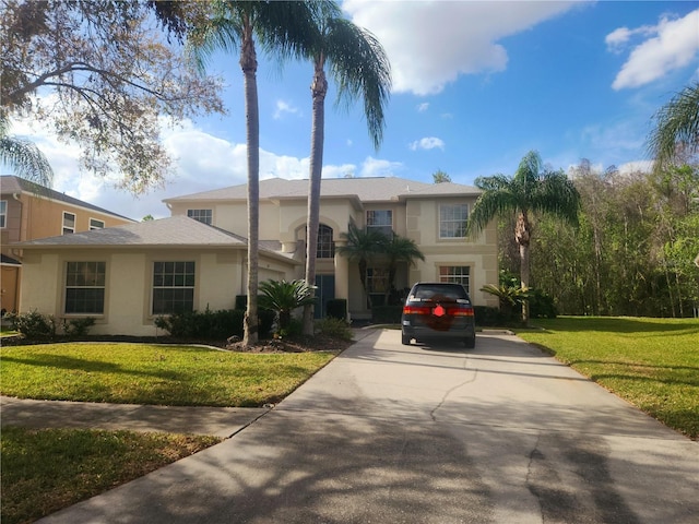 view of front of home with a garage, stucco siding, concrete driveway, and a front yard