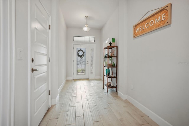 foyer with baseboards and wood tiled floor