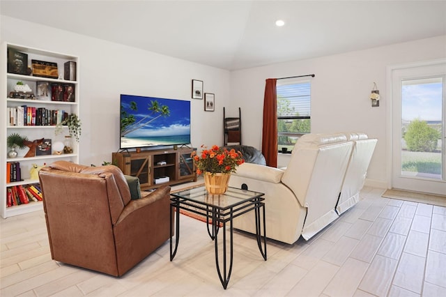 living area featuring recessed lighting, plenty of natural light, and lofted ceiling