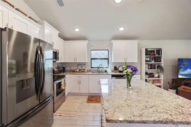 kitchen with a sink, appliances with stainless steel finishes, a center island, and white cabinetry