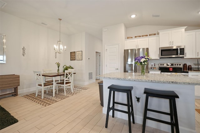 kitchen featuring light wood finished floors, visible vents, vaulted ceiling, appliances with stainless steel finishes, and an inviting chandelier