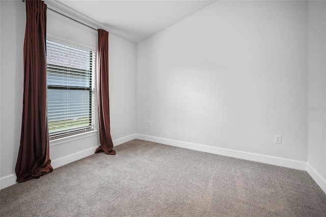 spare room with baseboards and carpet floors