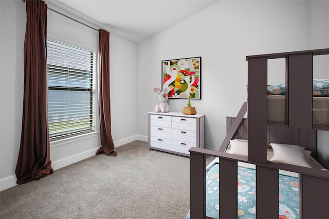 bedroom featuring baseboards, carpet, and vaulted ceiling