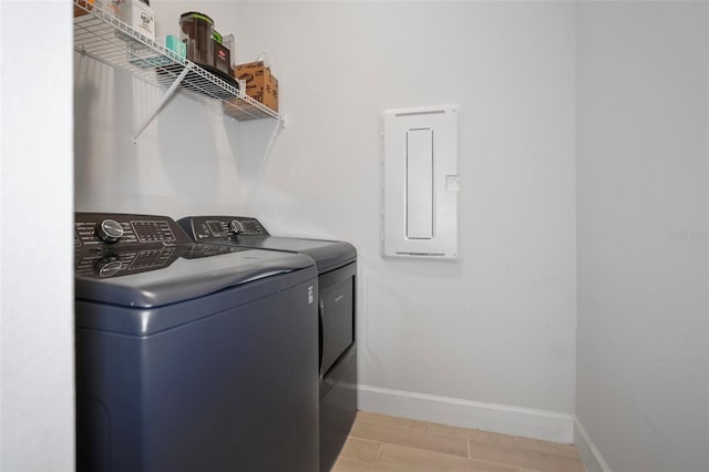 laundry area featuring laundry area, electric panel, separate washer and dryer, and baseboards