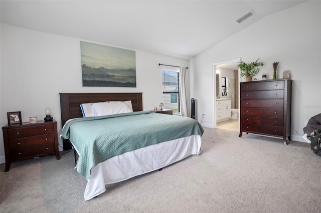 carpeted bedroom with lofted ceiling, baseboards, visible vents, and connected bathroom