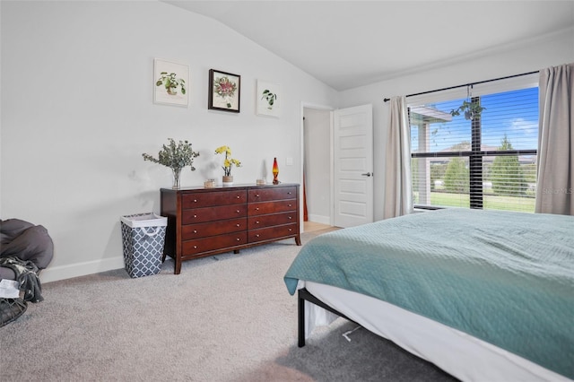 bedroom with vaulted ceiling, light colored carpet, and baseboards