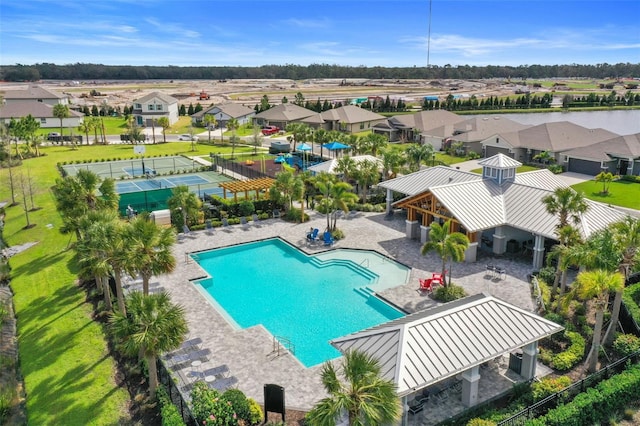 view of pool featuring a patio area, a residential view, a lawn, and fence