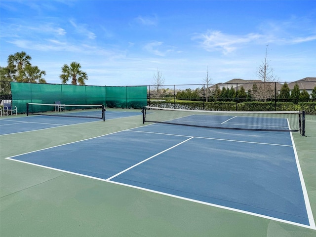 view of tennis court with community basketball court and fence