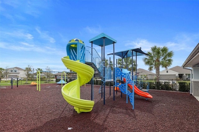 community playground featuring fence and a residential view