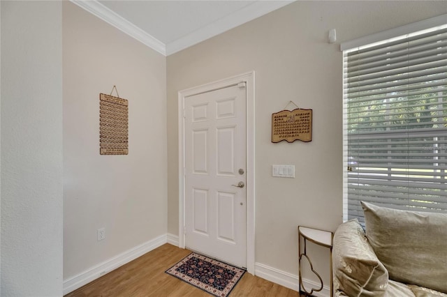 entryway with ornamental molding, baseboards, and wood finished floors