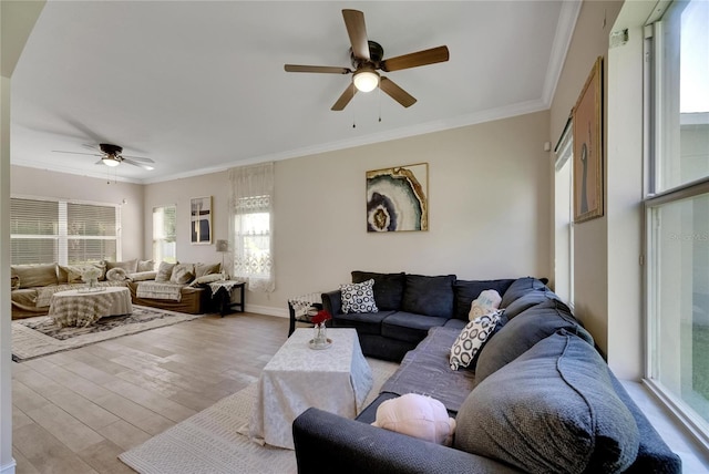 living area featuring light wood-style floors, a ceiling fan, baseboards, and crown molding