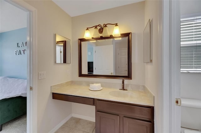 bathroom with toilet, vanity, baseboards, tile patterned floors, and ensuite bath