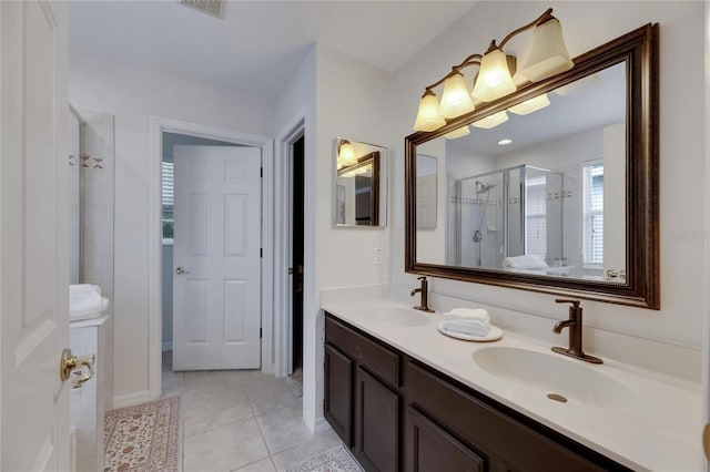 full bath with a shower stall, double vanity, a sink, and tile patterned floors