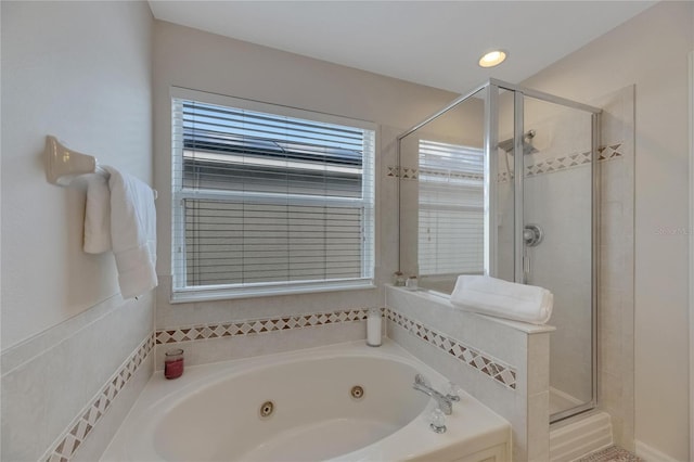 bathroom featuring a shower stall and a tub with jets