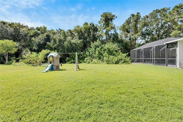 view of yard with a lanai and a playground