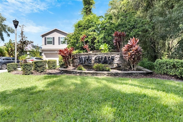 view of front of home with an attached garage, a front lawn, and stucco siding