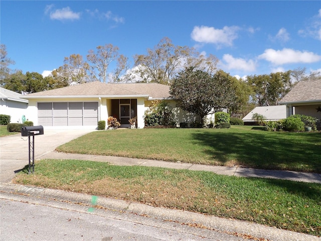 ranch-style home with a garage, a front yard, concrete driveway, and stucco siding