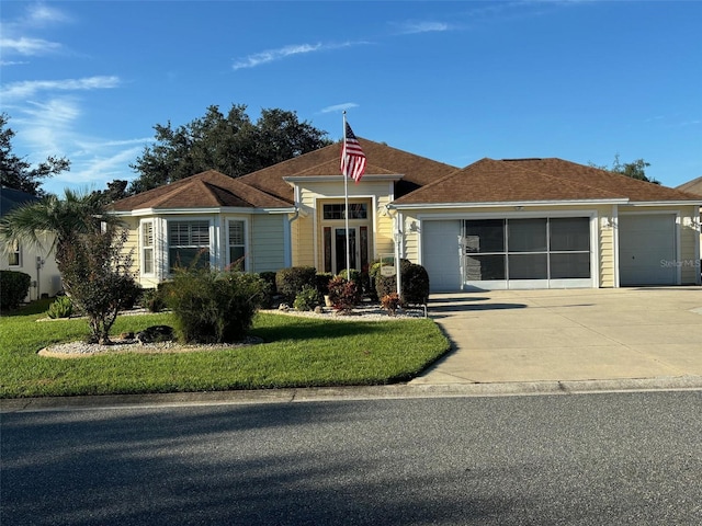 view of front of house featuring a garage, concrete driveway, and a front lawn