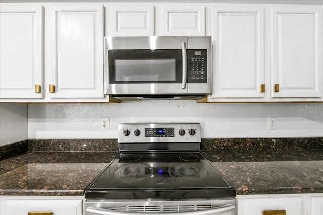 3616 Cypress Meadows Rd, Tampa, FL 33624 - kitchen featuring stainless steel appliances, white cabinets, and dark stone countertops