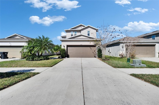 view of front of property with a garage, concrete driveway, a front lawn, and stucco siding