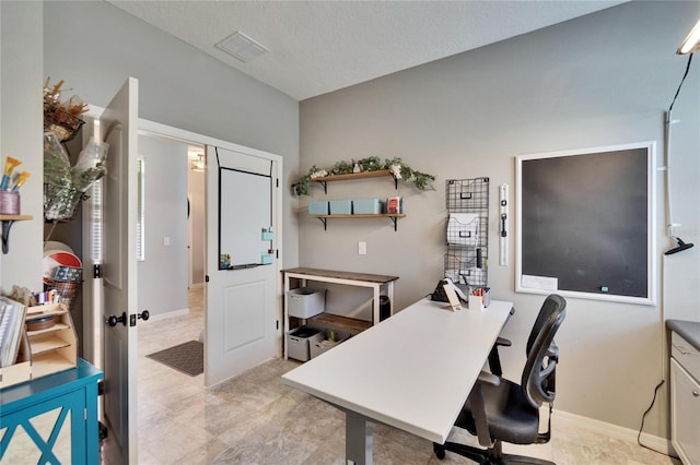 office space featuring visible vents, a textured ceiling, and baseboards