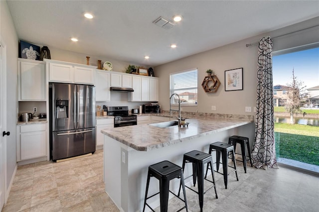 kitchen with white cabinets, a peninsula, stainless steel appliances, and light countertops