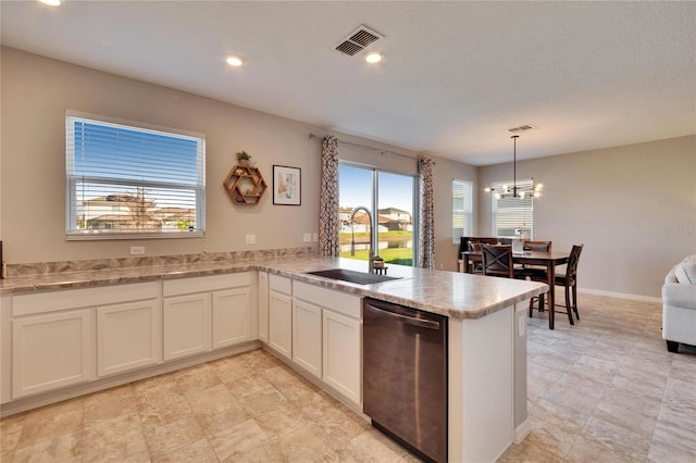 kitchen featuring a sink, visible vents, white cabinets, stainless steel dishwasher, and pendant lighting