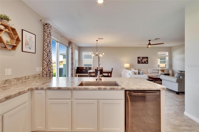 kitchen with white cabinets, dishwasher, open floor plan, pendant lighting, and a sink