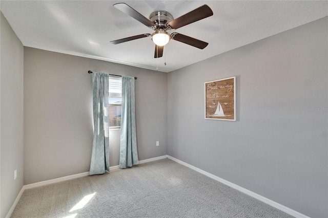 empty room featuring a ceiling fan, carpet, baseboards, and a textured ceiling