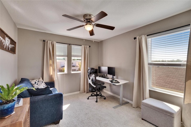 office space featuring plenty of natural light, baseboards, a ceiling fan, and light colored carpet