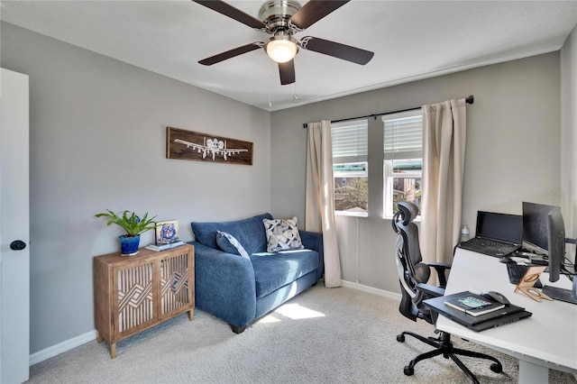 office area with light carpet, a ceiling fan, and baseboards