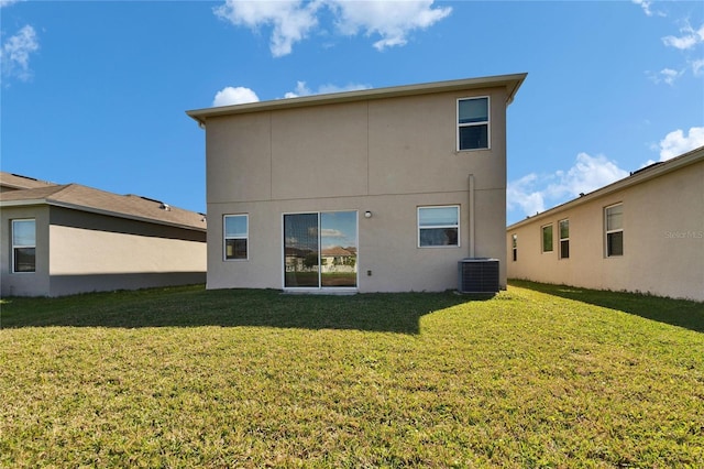 back of property featuring central air condition unit, a lawn, and stucco siding