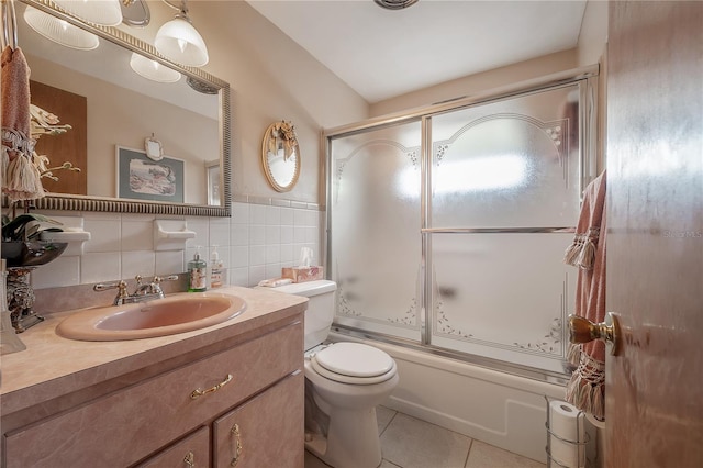 full bathroom featuring tile walls, vanity, tile patterned flooring, toilet, and enclosed tub / shower combo