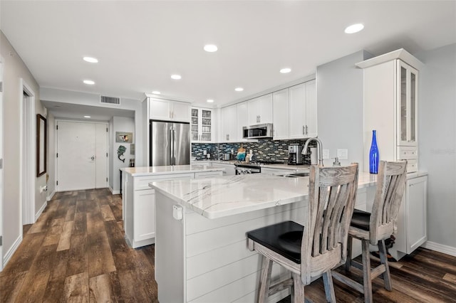690 Island Way Unit 1003, Clearwater Beach, FL 33767 - kitchen with stainless steel appliances, a sink, a peninsula, a kitchen island, and glass insert cabinets