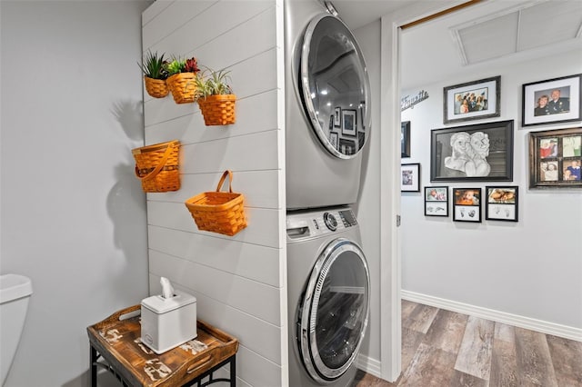 690 Island Way Unit 1003, Clearwater Beach, FL 33767 - laundry room with stacked washer / drying machine, wood finished floors, and baseboards
