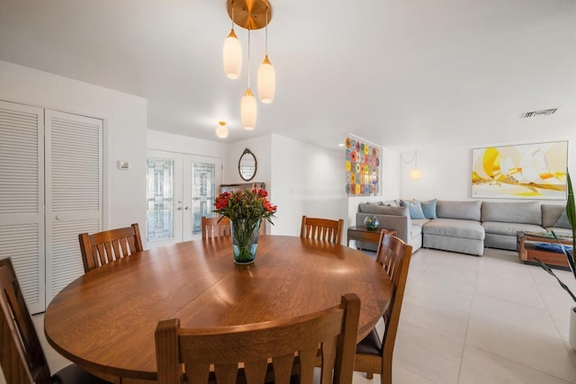 dining space with light tile patterned floors, french doors, and visible vents