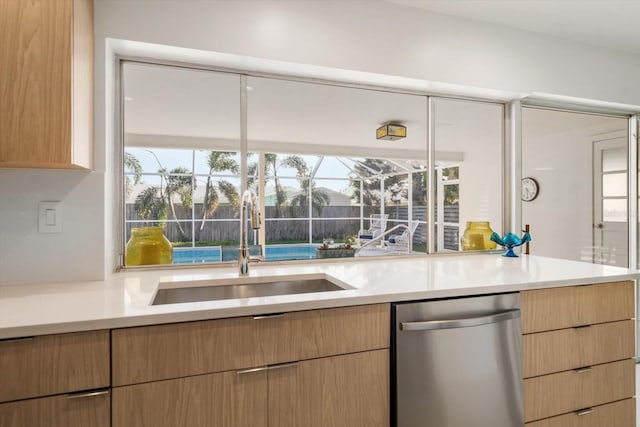 kitchen with modern cabinets, light countertops, a healthy amount of sunlight, stainless steel dishwasher, and a sink