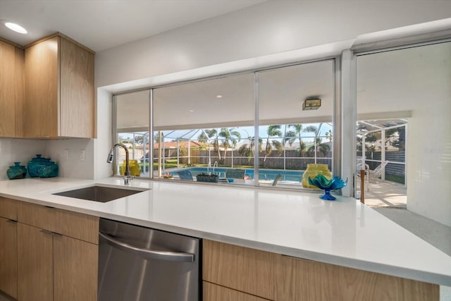 kitchen featuring dishwasher, a sunroom, modern cabinets, light countertops, and a sink