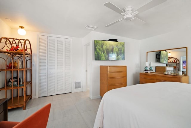 bedroom featuring a ceiling fan, a closet, visible vents, and light tile patterned flooring