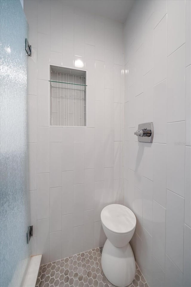 full bathroom featuring a shower stall and toilet