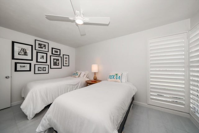 bedroom featuring a ceiling fan, light tile patterned flooring, and baseboards